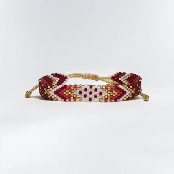 Handcrafted beaded bracelet with red and gold pattern.