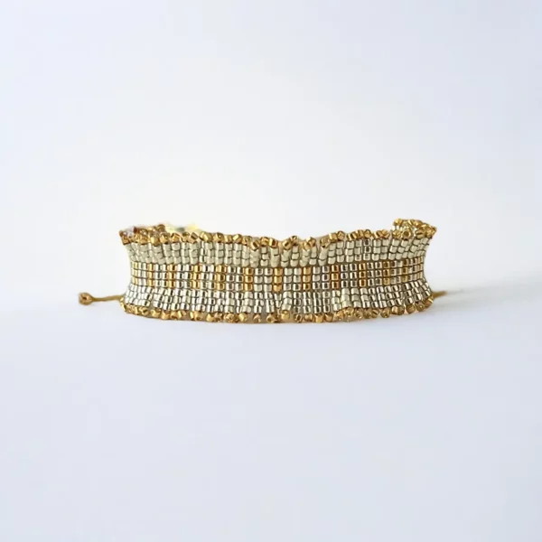 Gold and silver beaded bracelet on white background.