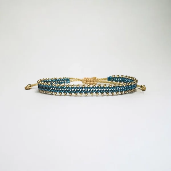 Beaded blue and gold bracelet on white background.
