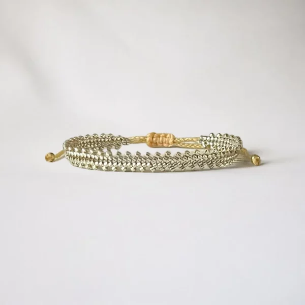 Gold mesh bracelet on white background.