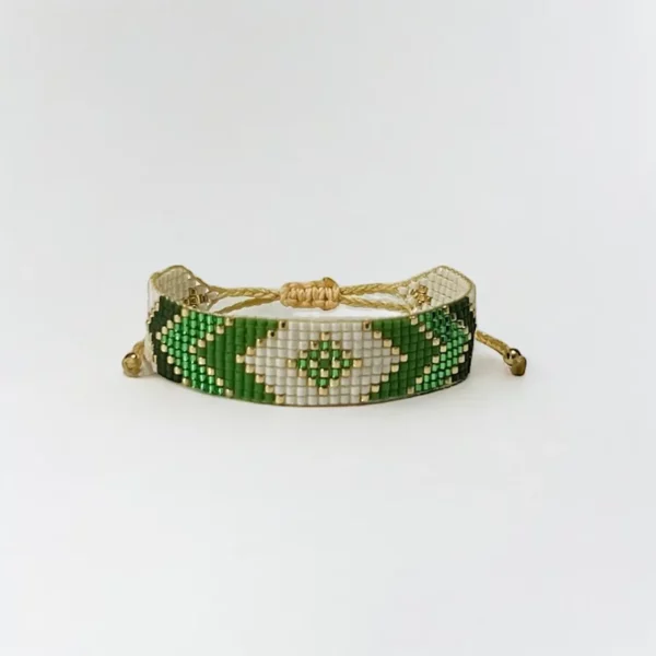 Green beaded bracelet with gold accents on white background.