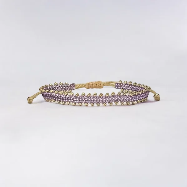 Gold and purple beaded bracelet on white.