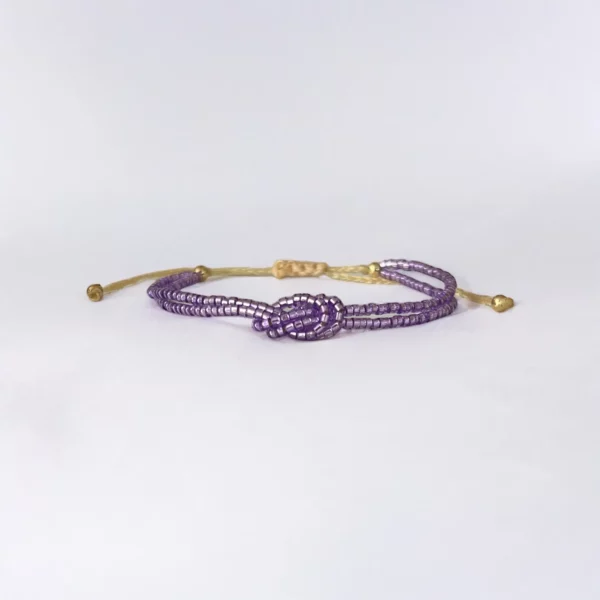 Purple beaded bracelet with gold accents.