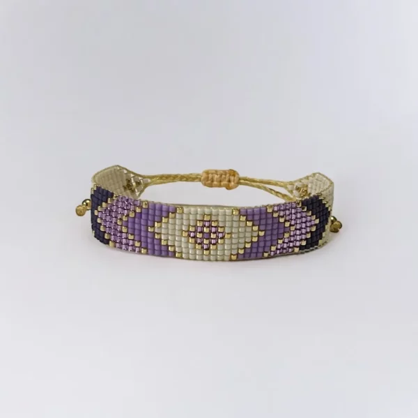 Beaded purple and gold bracelet on white background.