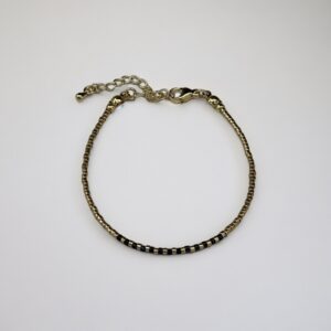Gold and black choker necklace on white background.
