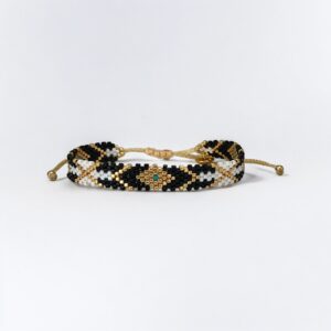 Beaded gold and black adjustable bracelet on white background
