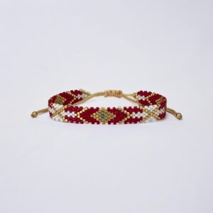 Beaded red and white friendship bracelet with gold accents.