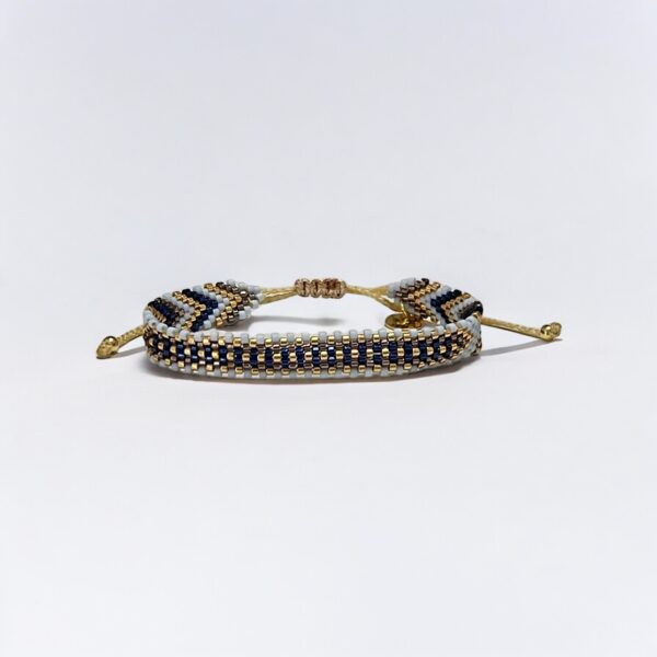 Beaded bracelet with gold accents on white background.