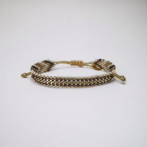 Beaded gold and silver friendship bracelet on white background.