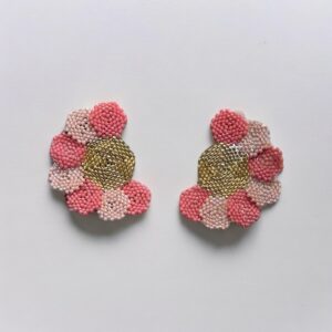 Beaded pink flower earrings on white background.