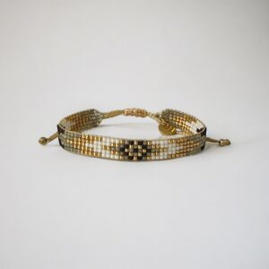 Beaded gold-tone adjustable bracelet on white background.