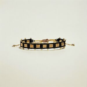 Black and gold beaded bracelet on white background.