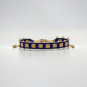 Gold and blue beaded bracelet on white.