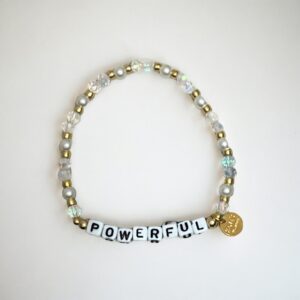 Beaded bracelet with 'POWERFUL' inscription and charm.