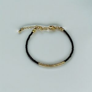 Gold and black beaded bracelet on white.