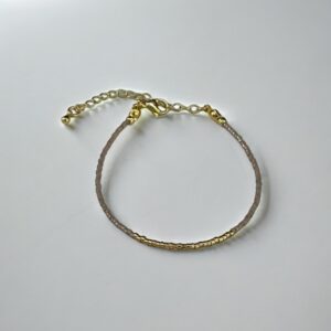 Gold and leather bracelet on white background.