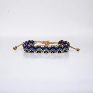Beaded blue and gold bracelet on white background.